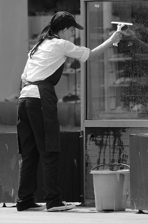 Lady cleaning windows in commercial property.