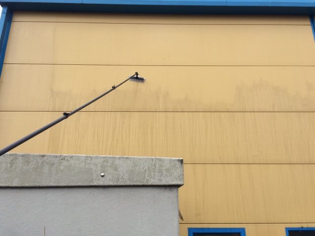 Water-fed pole cleaning commercial cladding.